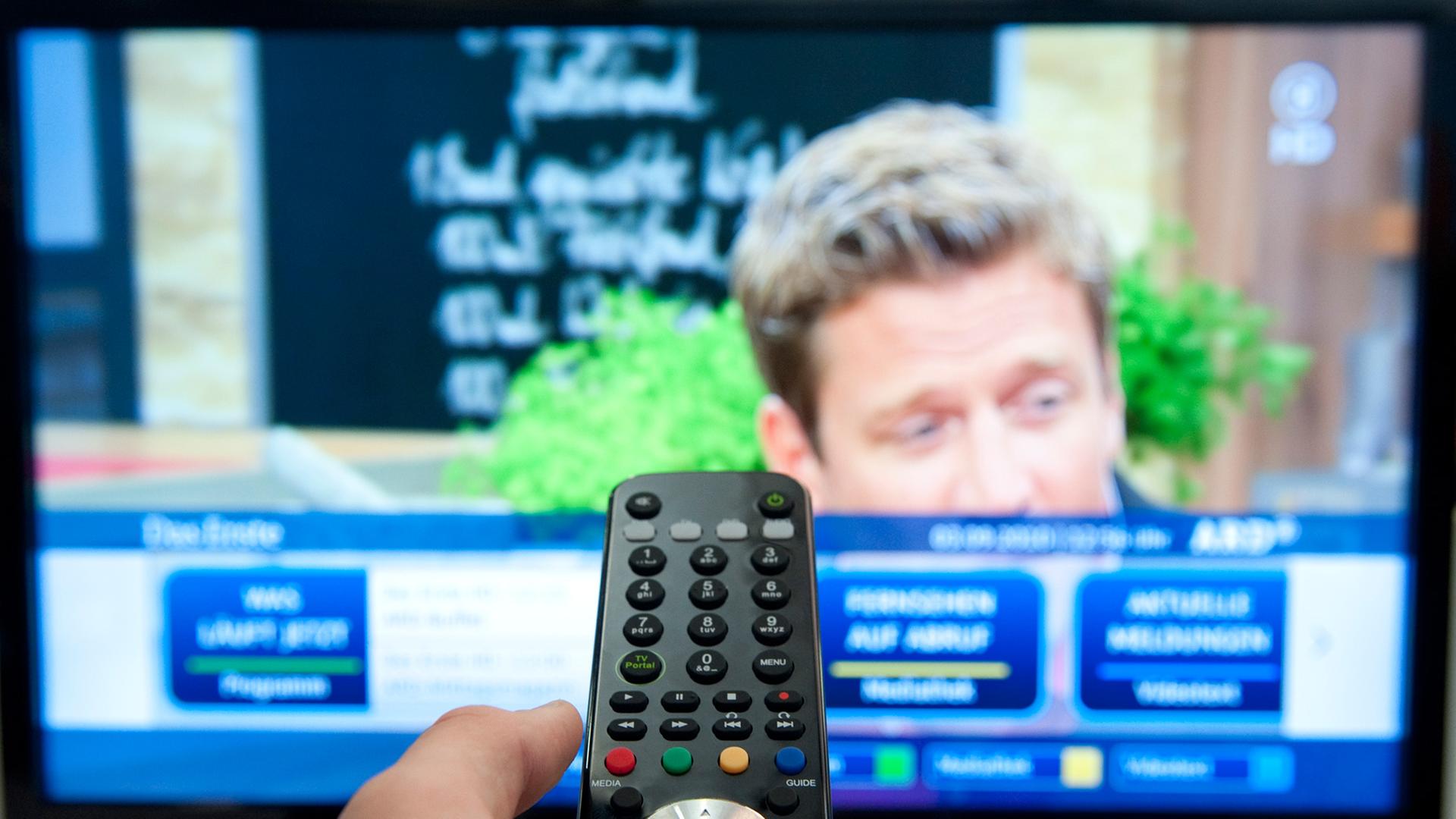 Eine Fernbedienung ist auf einen Fernseher gerichtet. Eine Fernbedienung ist auf einen Fernseher gerichtet.
