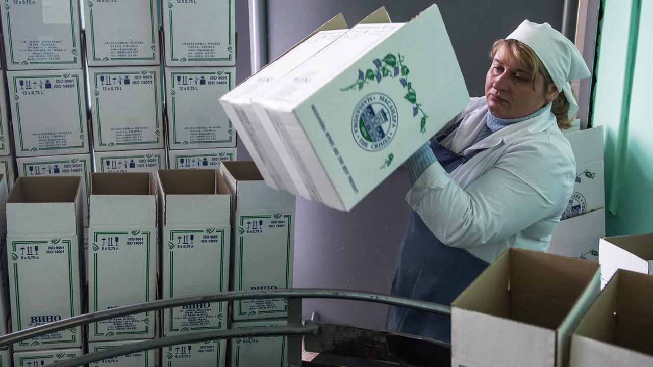 Eine Frau verpackt Weinflaschen in einem Betrieb auf der Krim. Eine Frau verpackt Weinflaschen in einem Betrieb auf der Krim.