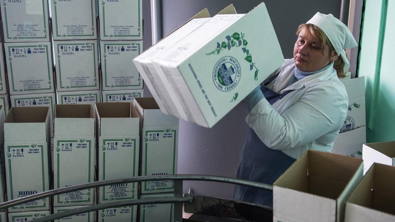 Eine Frau verpackt Weinflaschen in einem Betrieb auf der Krim. Eine Frau verpackt Weinflaschen in einem Betrieb auf der Krim.