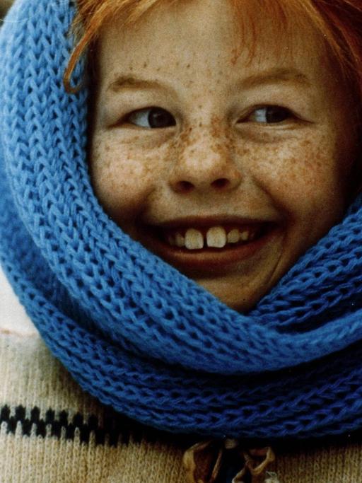 Pippi Langstrumpf eingehüllt in einen blauen Schal.