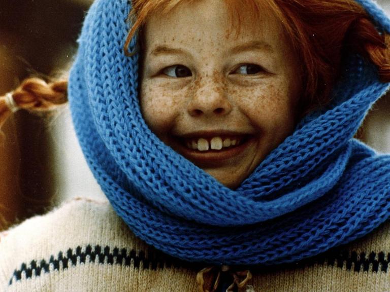 Pippi Langstrumpf eingehüllt in einen blauen Schal.