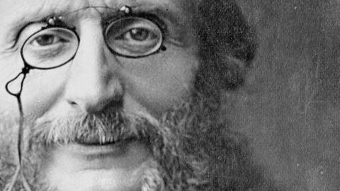 Ein realistisches fotoähnliches Porträt des älteren Komponisten, der seine Nickelbrille trägt