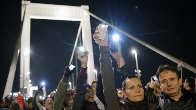 Menschen in Budapest protestieren mit ihren Smartphones gegen die geplante Internet-Steuer.