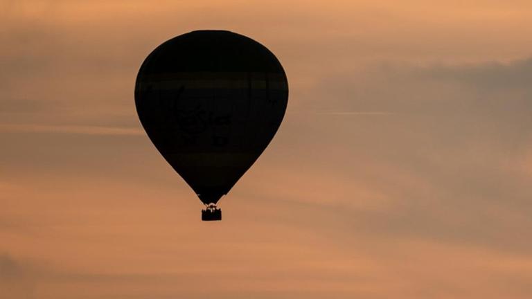 Ein Heißluftballon vor dem Abendhimmel.