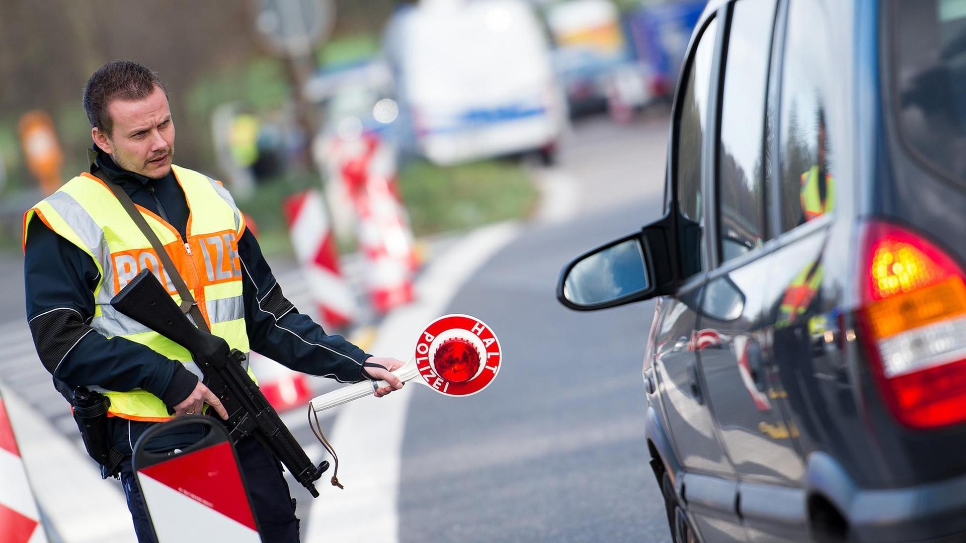Ein Polizist kontrolliert nahe der Grenze zu Belgien auf der Autobahn 44 bei Aachen ein Fahrzeug. Ein Polizist kontrolliert nahe der Grenze zu Belgien auf der Autobahn 44 bei Aachen ein Fahrzeug.