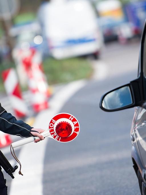 Ein Polizist kontrolliert nahe der Grenze zu Belgien auf der Autobahn 44 bei Aachen ein Fahrzeug.