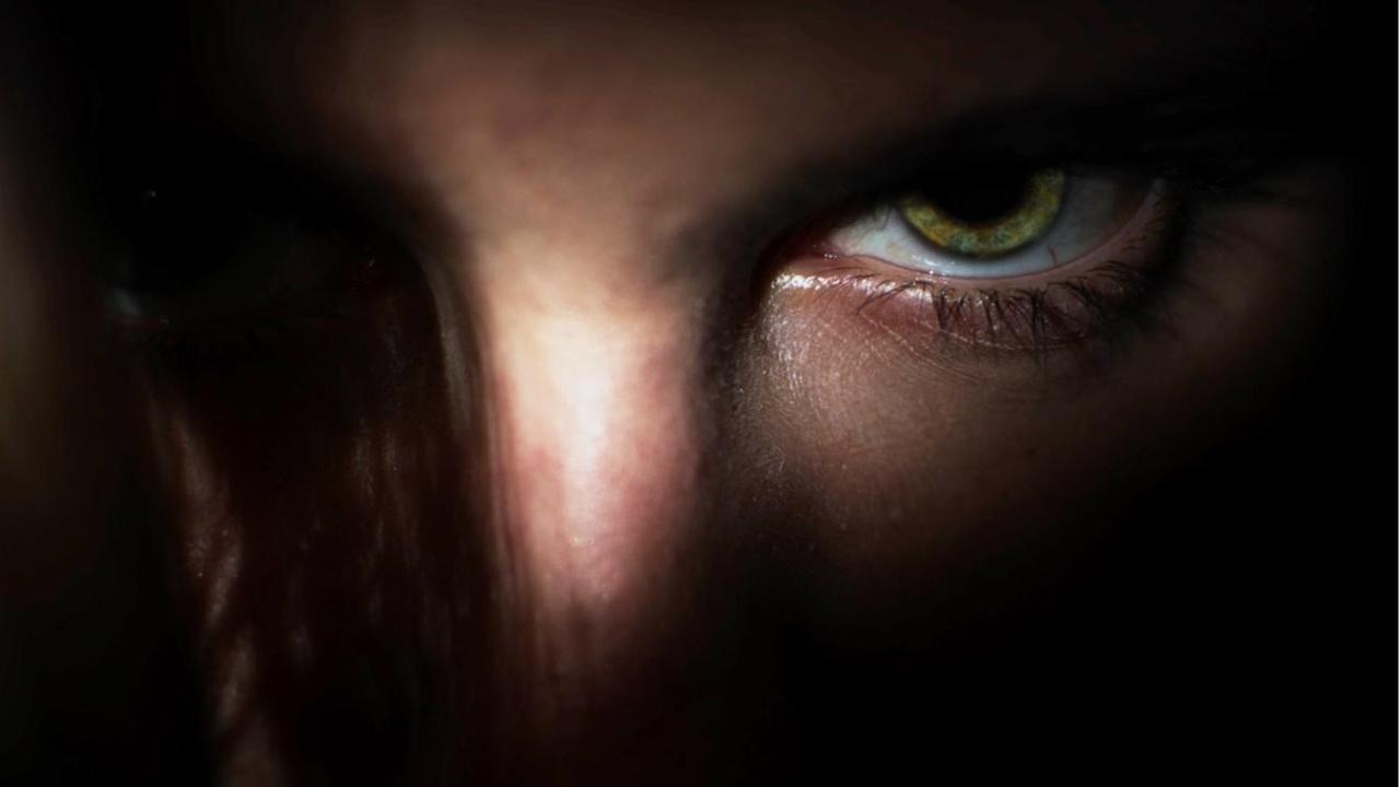 Ein Auge in einem dunklen Raum blickt den betrachter an, das Gesicht ist nicht zu erkennen. Ein Auge in einem dunklen Raum blickt den betrachter an, das Gesicht ist nicht zu erkennen.