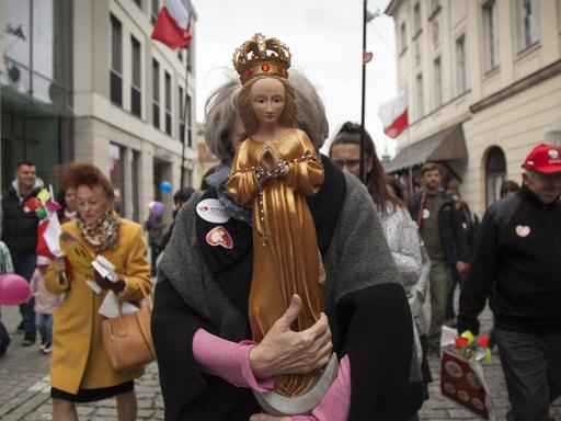 Eine Frau hält die Heilige Maria während des Nationalen Marsches für "Leben und Familie" vor ihr Gesicht, um für das traditionelle Verständnis der Ehe und des Lebens von der Empfängnis an zu demonstrieren.