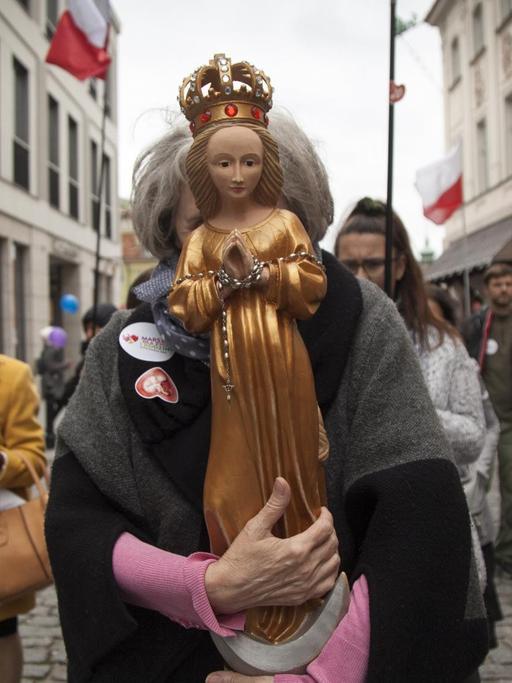 Eine Frau hält die Heilige Maria während des Nationalen Marsches für "Leben und Familie" vor ihr Gesicht, um für das traditionelle Verständnis der Ehe und des Lebens von der Empfängnis an zu demonstrieren.
