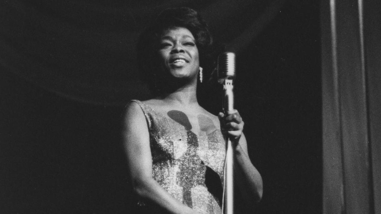 Eine historische schwarz-weiss Aufnahme der Jazzsängerin Sarah Vaughan, auf einer Bühne in London, 1963. Eine historische schwarz-weiss Aufnahme der Jazzsängerin Sarah Vaughan, auf einer Bühne in London, 1963.