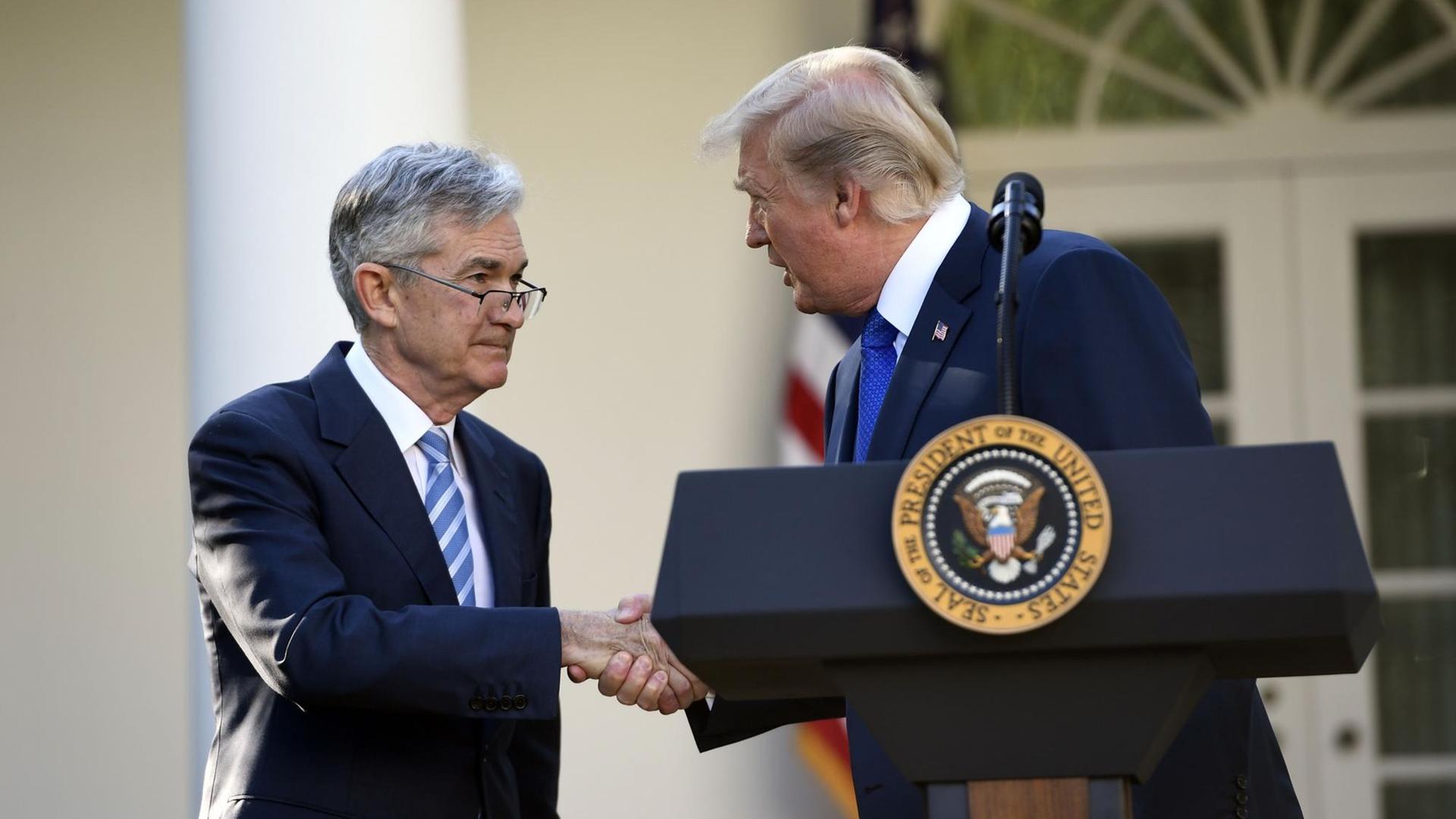 Donald Trump steht vor dem Weißen Haus in Washington und schüttelt die Hand von Jerome Powell. Donald Trump steht vor dem Weißen Haus in Washington und schüttelt die Hand von Jerome Powell.