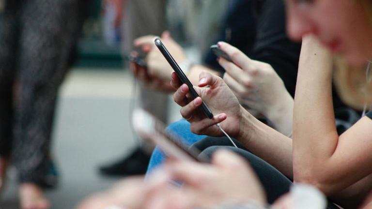 Mehrere Personen benutzen ihre Smartphones. Mehrere Personen benutzen ihre Smartphones.