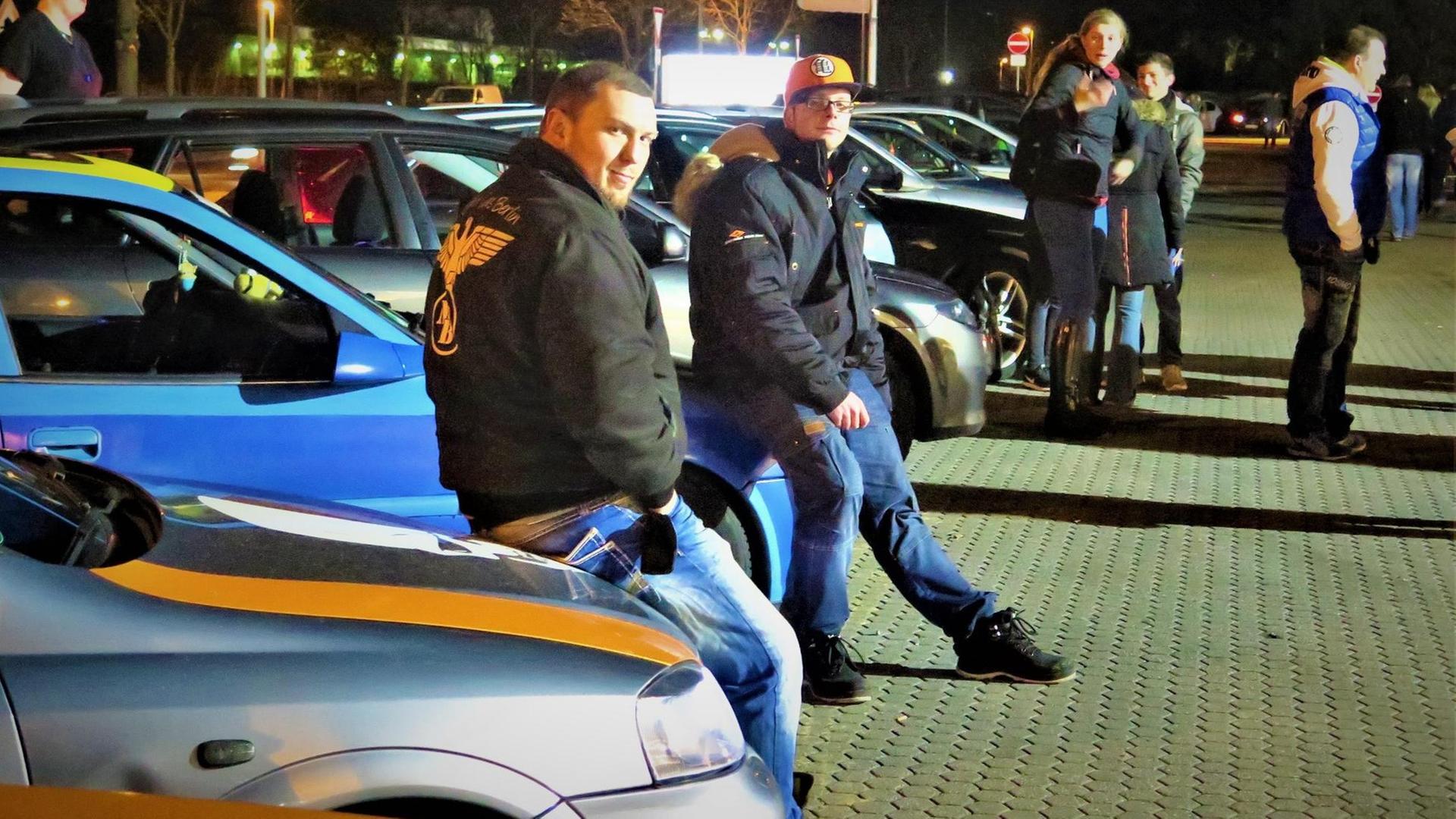 Auto-Tuner angelehnt an den Motorhauben ihrer Autos Auto-Tuner angelehnt an den Motorhauben ihrer Autos