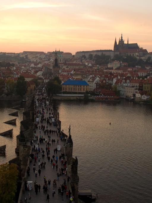 Blick vom Altstädter Brückenturm bei Sonnenuntergang über die Karlsbrücke auf die Prager Kleinseite mit der Prager Burg und dem Veitsdom