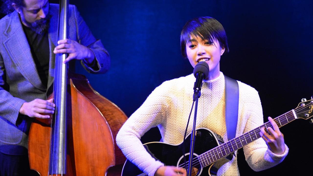 Die Singer/Songwriterin Le-Thanh Ho singt zur Gitarre, im Hintergrund ihr Kontrabassist
