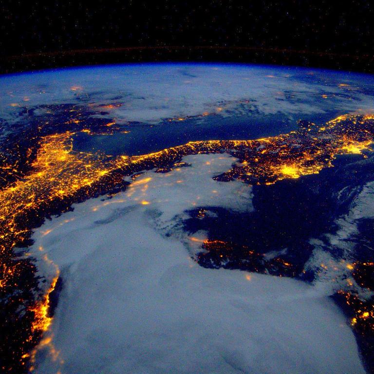 Foto der Weltkugel bei Nacht mit den  Lichtflächen der Städte, am 25. Januar 2016 von der Internationalen Raumstation ISS aus aufgenommen.
