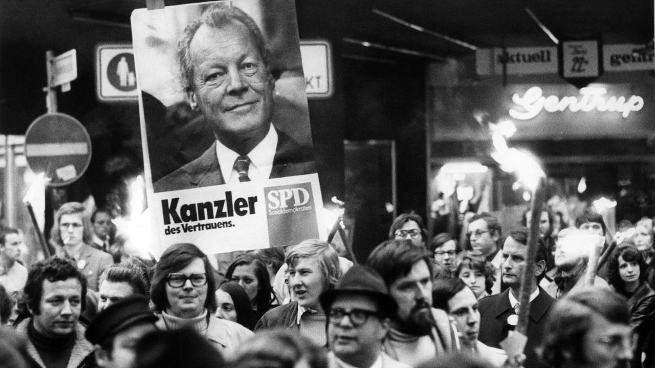 Demonstranten tragen Fackeln und ein Wahlplakat Willy Brandts mit der Aufschrift "Kanzler des Vertrauens".