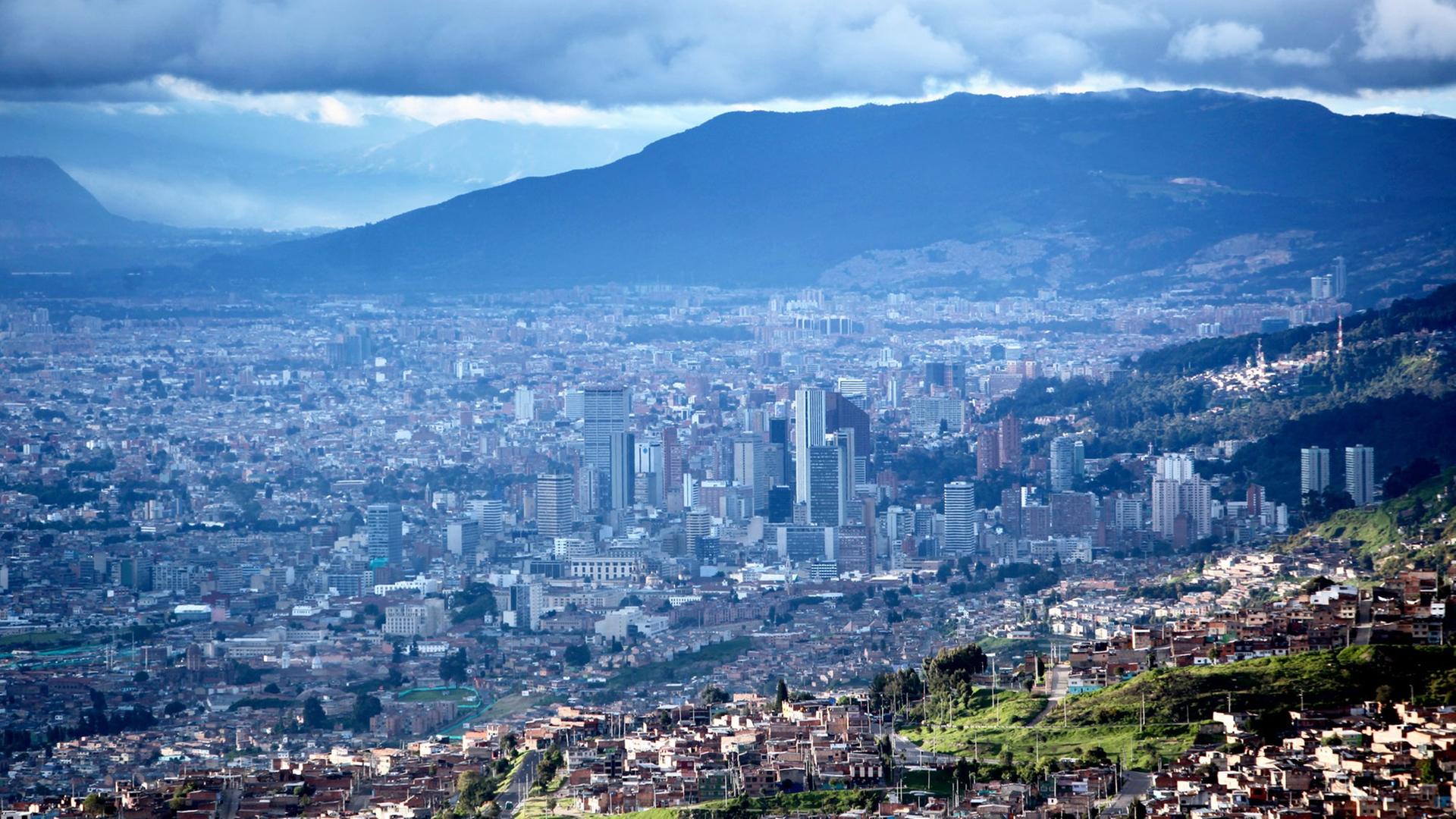 Luftansicht von Bogota, die Hauptstadt von Kolumbien vom Berg. Bogotá ist die Hauptstadt Kolumbiens und Verwaltungszentrum des Departamentos Cundinamarca. Mit ihren 6,8 Millionen Einwohnern im eigentlichen Stadtgebiet und 7,9 Millionen in der Agglomeration (Volkszaehlung 2005) ist Bogotá der groesste staedtische Ballungsraum Kolumbiens und ausserdem eine der am schnellsten wachsenden Metropolen Suedamerikas; Luftansicht von Bogota, die Hauptstadt von Kolumbien vom Berg. Bogotá ist die Hauptstadt Kolumbiens und Verwaltungszentrum des Departamentos Cundinamarca. Mit ihren 6,8 Millionen Einwohnern im eigentlichen Stadtgebiet und 7,9 Millionen in der Agglomeration (Volkszaehlung 2005) ist Bogotá der groesste staedtische Ballungsraum Kolumbiens und ausserdem eine der am schnellsten wachsenden Metropolen Suedamerikas;