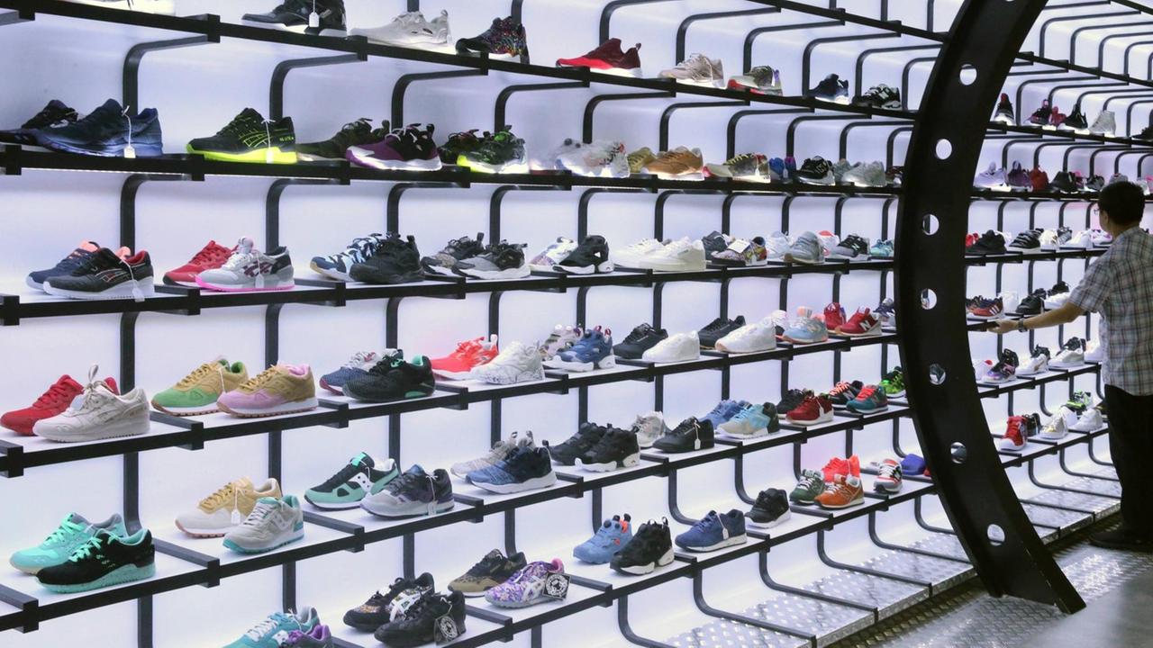 Sportschuhe auf einem erleuchteten Regal in einem Geschäft Sportschuhe auf einem erleuchteten Regal in einem Geschäft