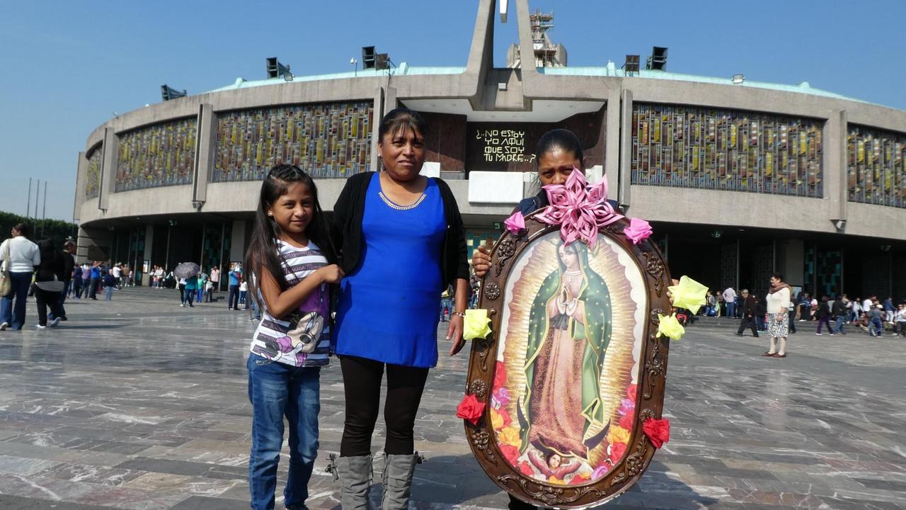 Besucherinnen der Basilika mit einem Heiligenbild für die Jungfrau von Guadalupe. Besucherinnen der Basilika mit einem Heiligenbild für die Jungfrau von Guadalupe.