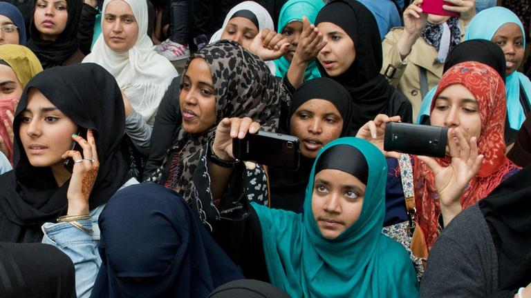 Junge Frauen verfolgen eine Kundgebung des radikalen Salafistenpredigers Pierre Vogel in Offenbach am Main.