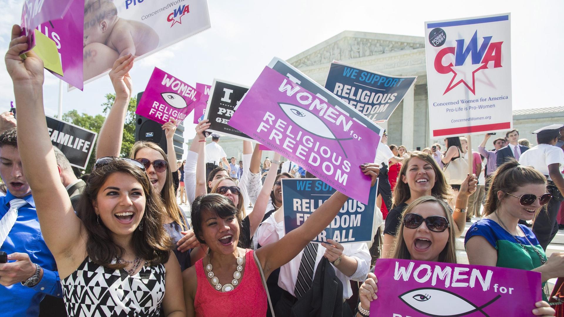 Abtreibungsgegner halten Plakate mit der Aufschrift "Women for religious freedom" vor dem Supreme Court, dem Obersten Gerichtshof in den USA. Abtreibungsgegner halten Plakate mit der Aufschrift "Women for religious freedom" vor dem Supreme Court, dem Obersten Gerichtshof in den USA.