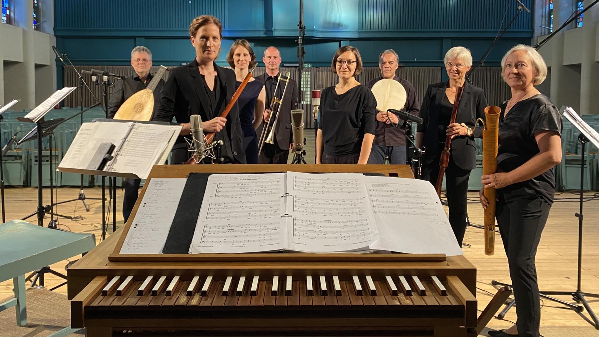Über die Tasten einer Truhenorgel hinweg kann man die Mitglieder des Ensembles mit ihren Instrumenten sehen. Über die Tasten einer Truhenorgel hinweg kann man die Mitglieder des Ensembles mit ihren Instrumenten sehen.