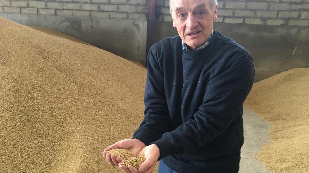 Farmer Charlie Adam hält eine Handvoll Getreidekörner in die Kamera