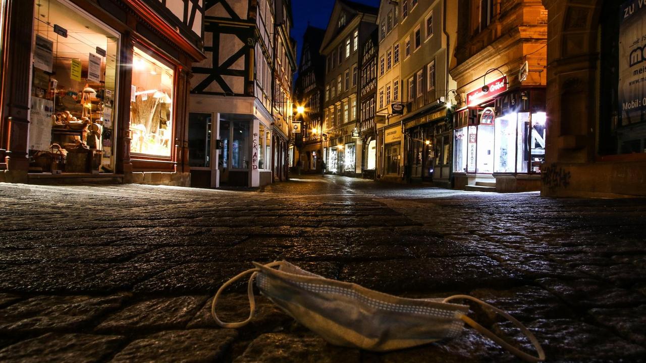 Ein Mund-Nasen-Schutz liegt auf einer menschenleeren Straße in der Marburgs Altstadt Ein Mund-Nasen-Schutz liegt auf einer menschenleeren Straße in der Marburgs Altstadt