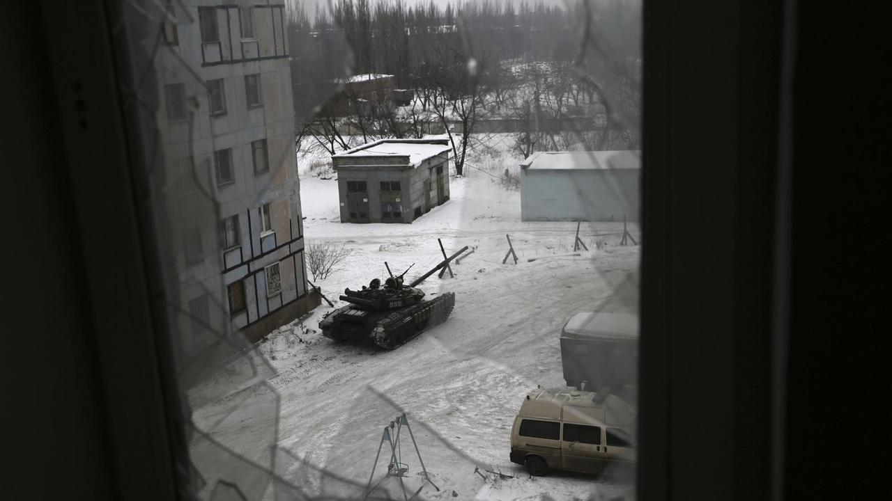 Blick durch ein zerstörtes Fenster auf einen Panzer der ukrainischen Armee in der Stadt Awdijiwka in der Ost-Ukraine. Blick durch ein zerstörtes Fenster auf einen Panzer der ukrainischen Armee in der Stadt Awdijiwka in der Ost-Ukraine.