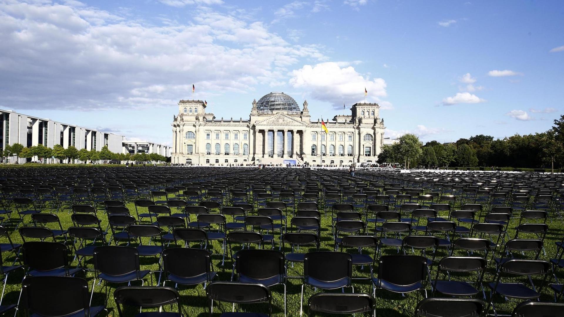 Tausende Stühle stehen auf dem Rasen vor dem Reichstagsgebäude in Berlin, um an das Schicksal der Geflüchteten auf Lesbos aufmerksam zu machen. Tausende Stühle stehen auf dem Rasen vor dem Reichstagsgebäude in Berlin, um an das Schicksal der Geflüchteten auf Lesbos aufmerksam zu machen.