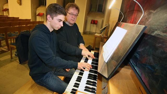 Diözesanmusikdirektor Gregor Frede (r) gibt am 07.12.2017 in der Kirche des Juliusspitals in Würzburg (Bayern) dem 17-jährigen Michael Netrval Unterricht an der Orgel.