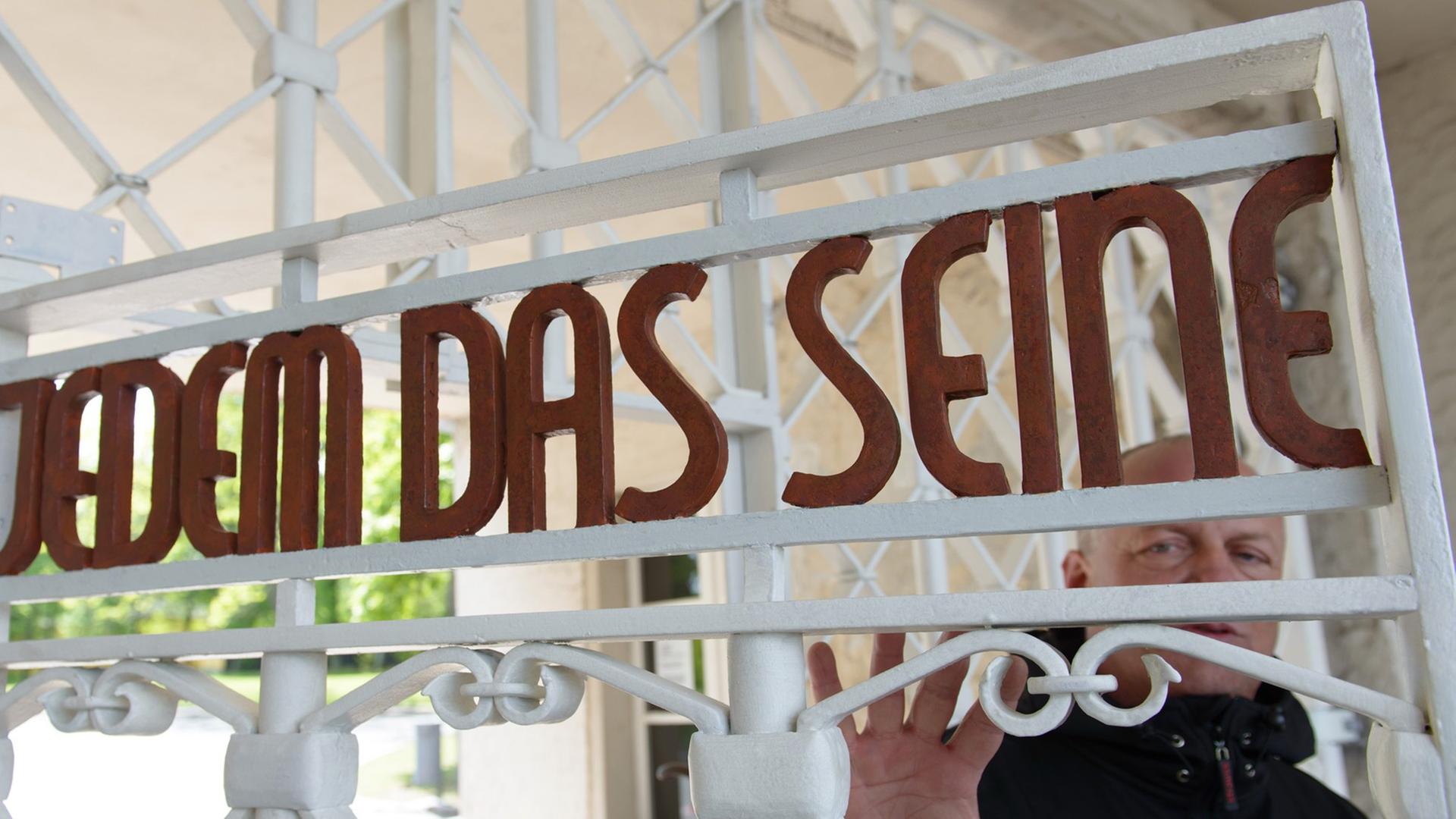 Restaurator Bernhard Mai steht in der Gedenkstätte Buchenwald am restaurierten und nach Befunden in den originalen Farben gestrichene Lagertor des ehemaligen Konzentrationslagers mit der Inschrift "Jedem das Seine". Restaurator Bernhard Mai steht in der Gedenkstätte Buchenwald am restaurierten und nach Befunden in den originalen Farben gestrichene Lagertor des ehemaligen Konzentrationslagers mit der Inschrift "Jedem das Seine".