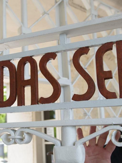 Restaurator Bernhard Mai steht in der Gedenkstätte Buchenwald am restaurierten und nach Befunden in den originalen Farben gestrichene Lagertor des ehemaligen Konzentrationslagers mit der Inschrift "Jedem das Seine".