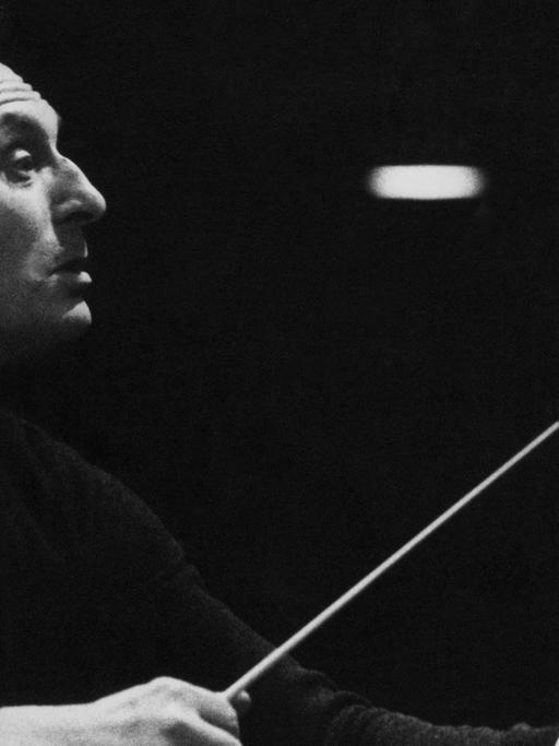 Carlo Maria Giulini stand zum ersten Mal 1944 am Dirigentenpult, als er das Festkonzert zur Befreiung Italiens durch die Aliierten leitete. Hier ist er auf einem Schwarz-Weiß Foto zu sehen mit Dirigentenstab im Profil