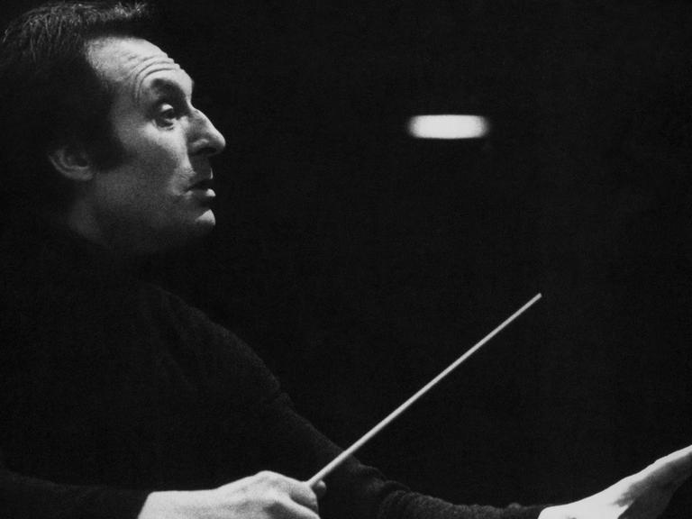 Carlo Maria Giulini stand zum ersten Mal 1944 am Dirigentenpult, als er das Festkonzert zur Befreiung Italiens durch die Aliierten leitete. Hier ist er auf einem Schwarz-Weiß Foto zu sehen mit Dirigentenstab im Profil
