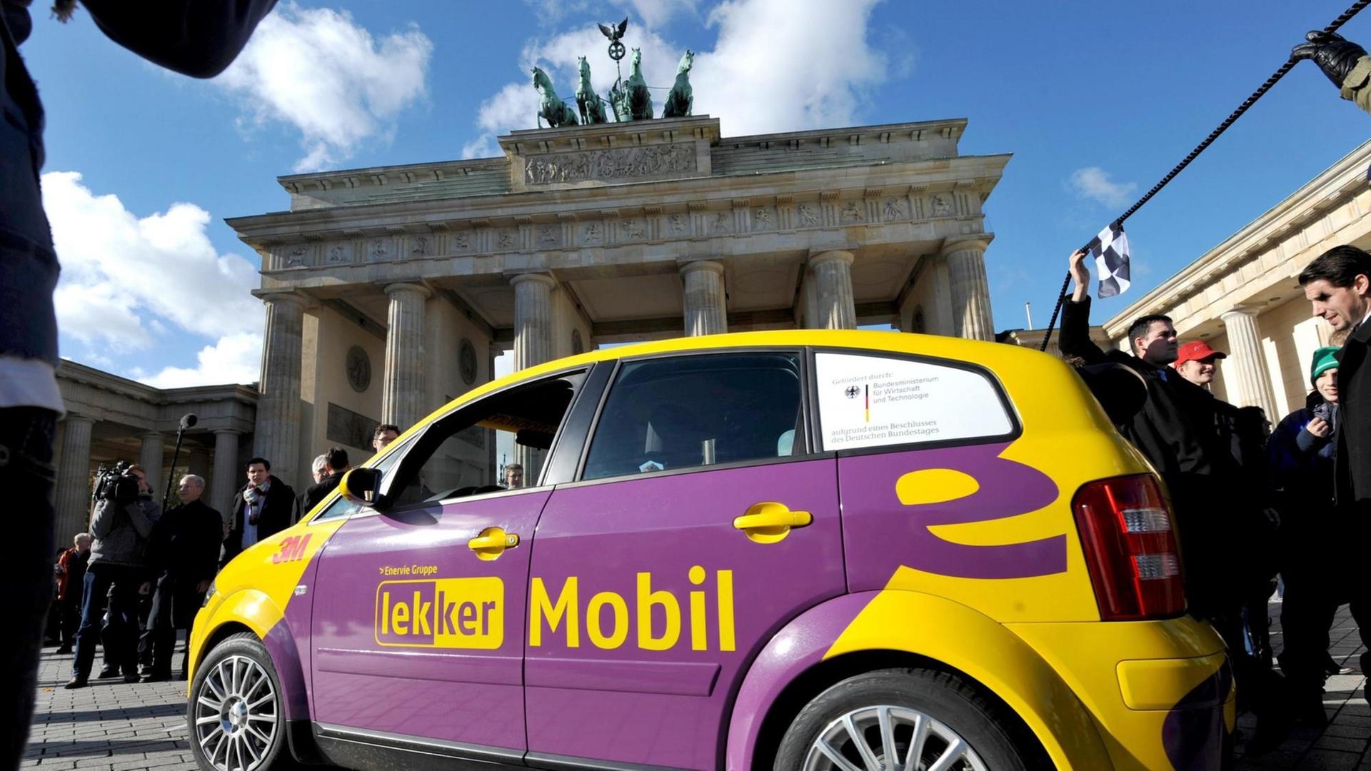 Mirko Hannemann mit einem umgebauten Audi mit Kolibir-Akkus vor dem Brandenburger Tor in Berlin nach seiner Fahrt von München.