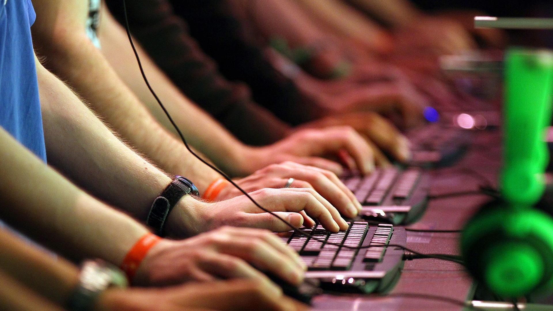 Messebesucher stehen in Köln auf der Gamescom an Computertastaturen. Messebesucher stehen in Köln auf der Gamescom an Computertastaturen.
