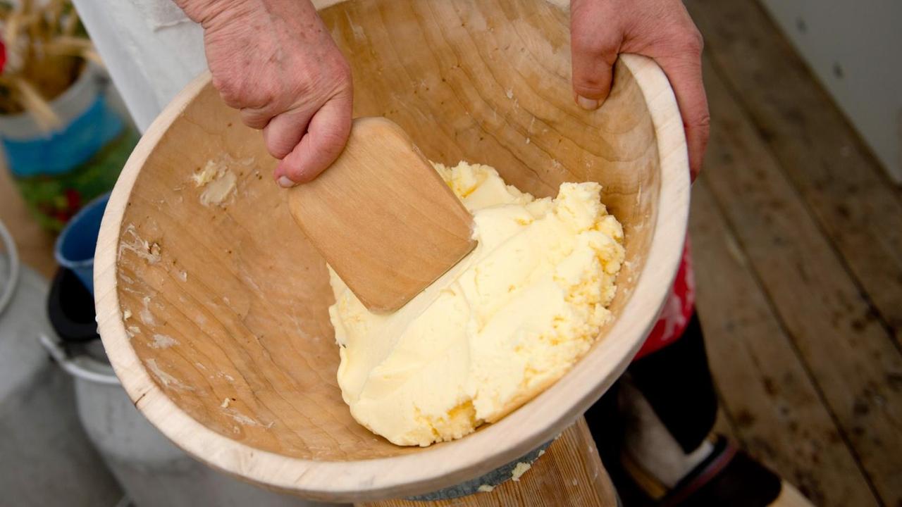 Butterproduktion im Butterfass: Eine Frau knetet auf der brandenburgischen Landwirtschaftsausstellung Butter aus. Butterproduktion im Butterfass: Eine Frau knetet auf der brandenburgischen Landwirtschaftsausstellung Butter aus.