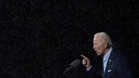 Joe Biden hält eine Rede im strömenden Regen.