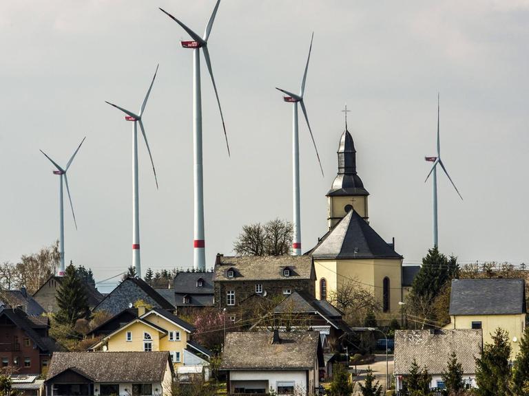 Der Ort Mörsdorf im Rhein-Hunsrück-Kreis mit der katholischen Kirche und hinter dem Ort fünf Windenergieanlagen.