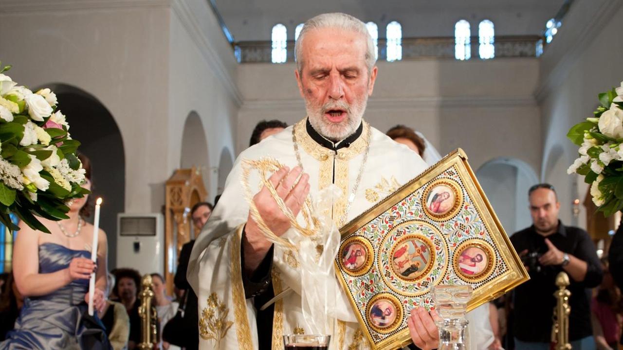 Ein griechisch-orthodoxer Priester bei einer Trauung in der "Kirche der Verklärung Christi" in Athen Ein griechisch-orthodoxer Priester bei einer Trauung in der "Kirche der Verklärung Christi" in Athen