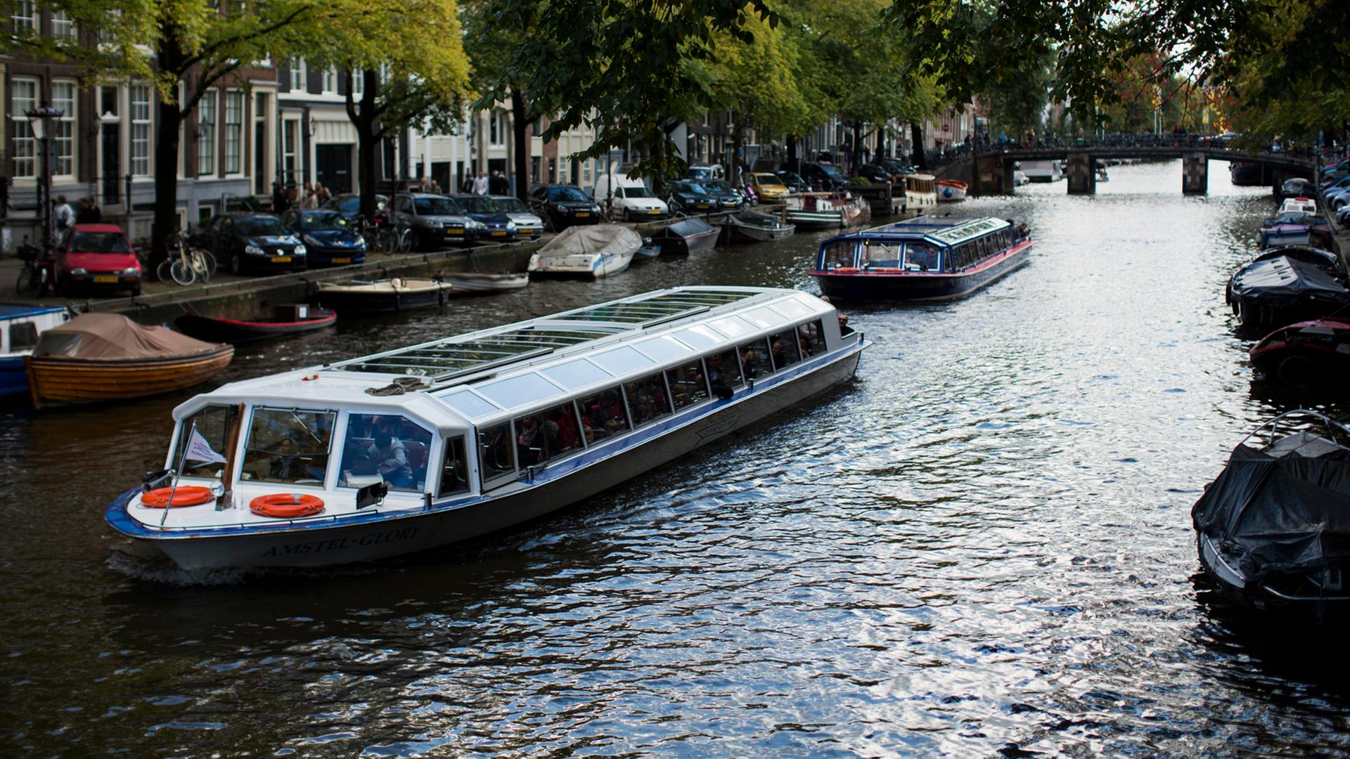 Ein Schiff fährt durch eine Gracht in Amsterdam.