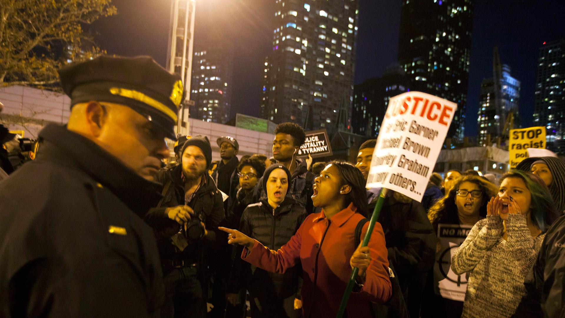 Demonstranten schreien in New York Polizisten an, die ihnen den Weg versperren. Demonstranten schreien in New York Polizisten an, die ihnen den Weg versperren.