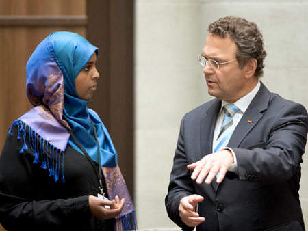 Bundesinnenminister Friedrich und Mahada Wayha, Delegierte der Jungen Islam Konferenz, unterhalten sich während der Islamkonferenz am 07.05.2013