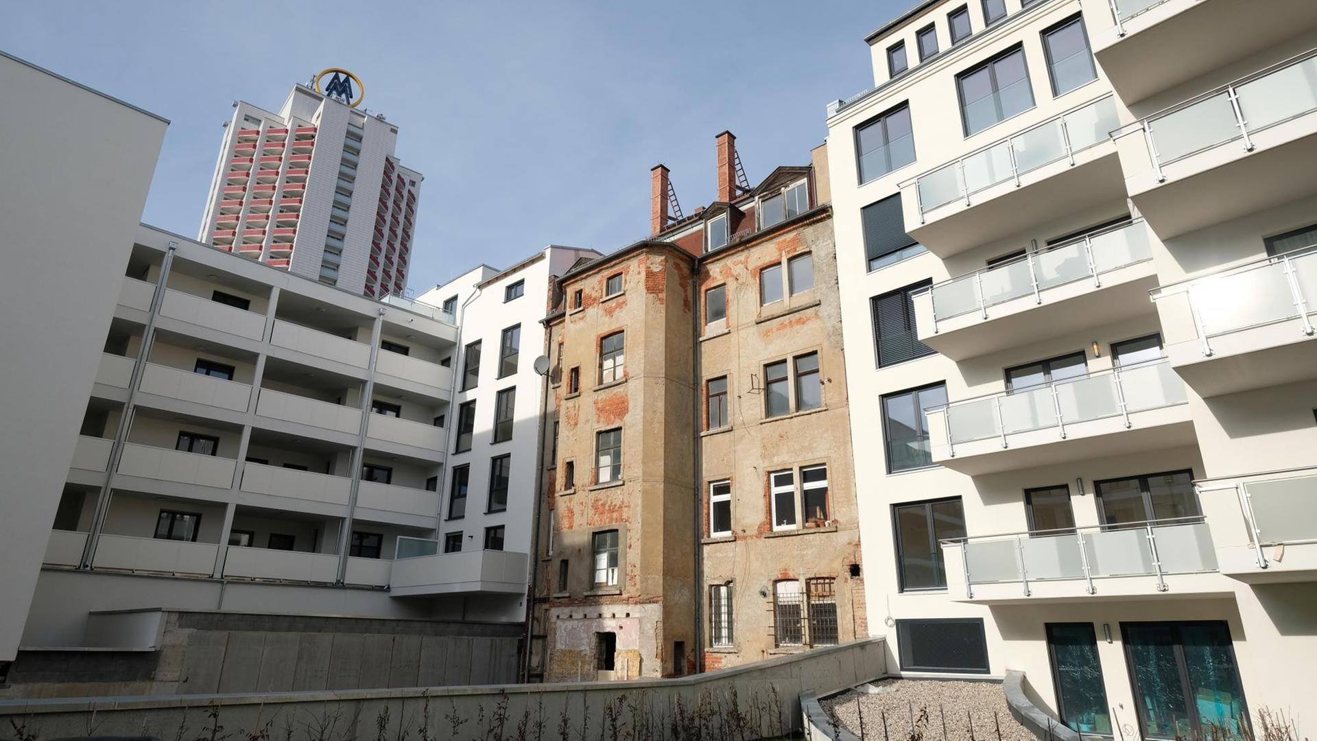 30.01.2019, Sachsen, Leipzig: Ein leerstehender, unsanierter Altbau steht zwischen noch unbewohnten Neubauten im Zentrum der Stadt, im Hintergrund ist das Wintergartenhochhaus zu sehen. 30.01.2019, Sachsen, Leipzig: Ein leerstehender, unsanierter Altbau steht zwischen noch unbewohnten Neubauten im Zentrum der Stadt, im Hintergrund ist das Wintergartenhochhaus zu sehen.