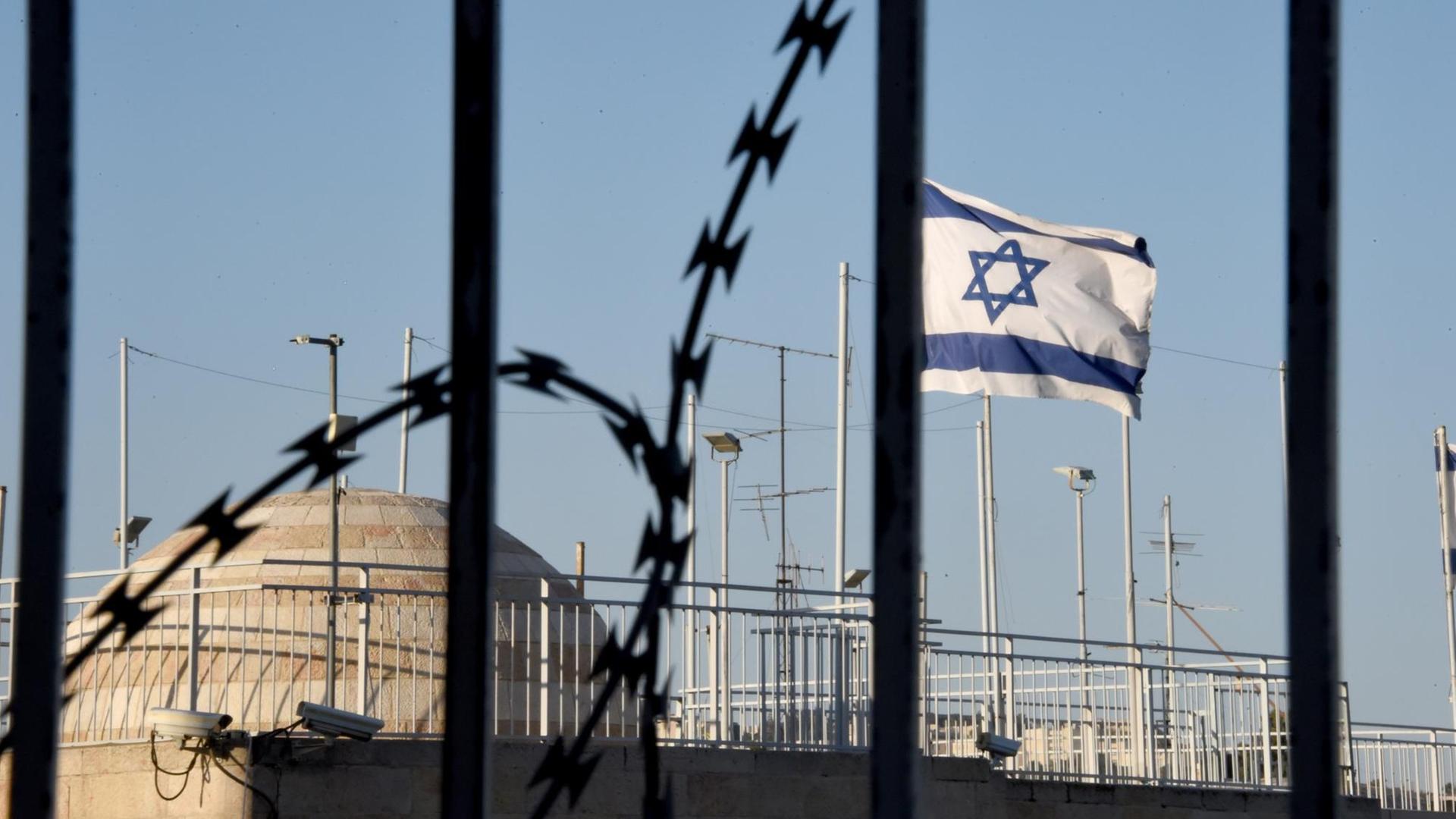Die israelische Flagge weht am 07.04.2016 hinter Stacheldraht in der Altstadt von Jerusalem. Die israelische Flagge weht am 07.04.2016 hinter Stacheldraht in der Altstadt von Jerusalem.