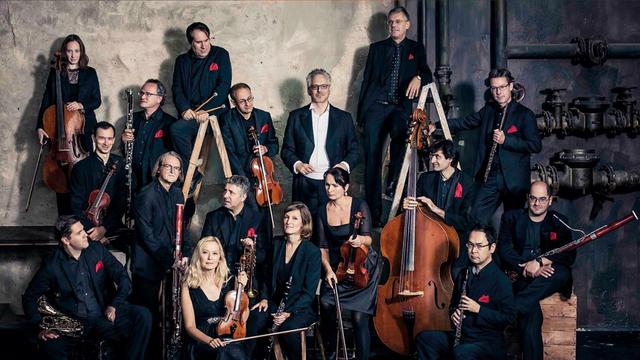 Die Musiker der Taschenphilharmonie München mit ihren Instrumenten und ihrem Dirigenten Peter Stangel.