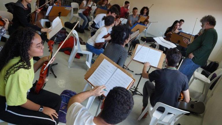 Mehrere junge Musiker sitzen mit ihren Instrumenten vor ihren Notenständern
