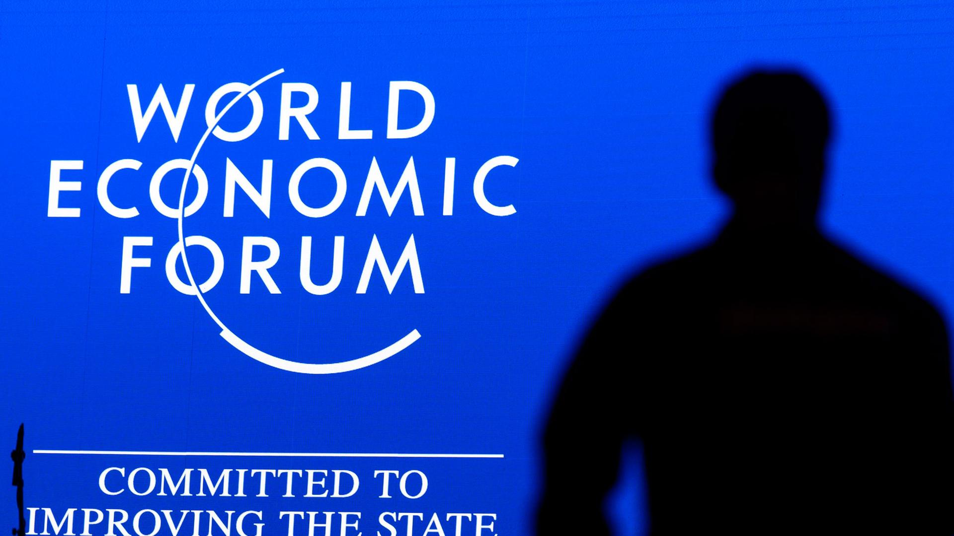 Das Logo des Weltwirtschaftsforum mit der Unterzeile "Committed to Improving the State of the World", davor der Schattenriss eines Mannes.